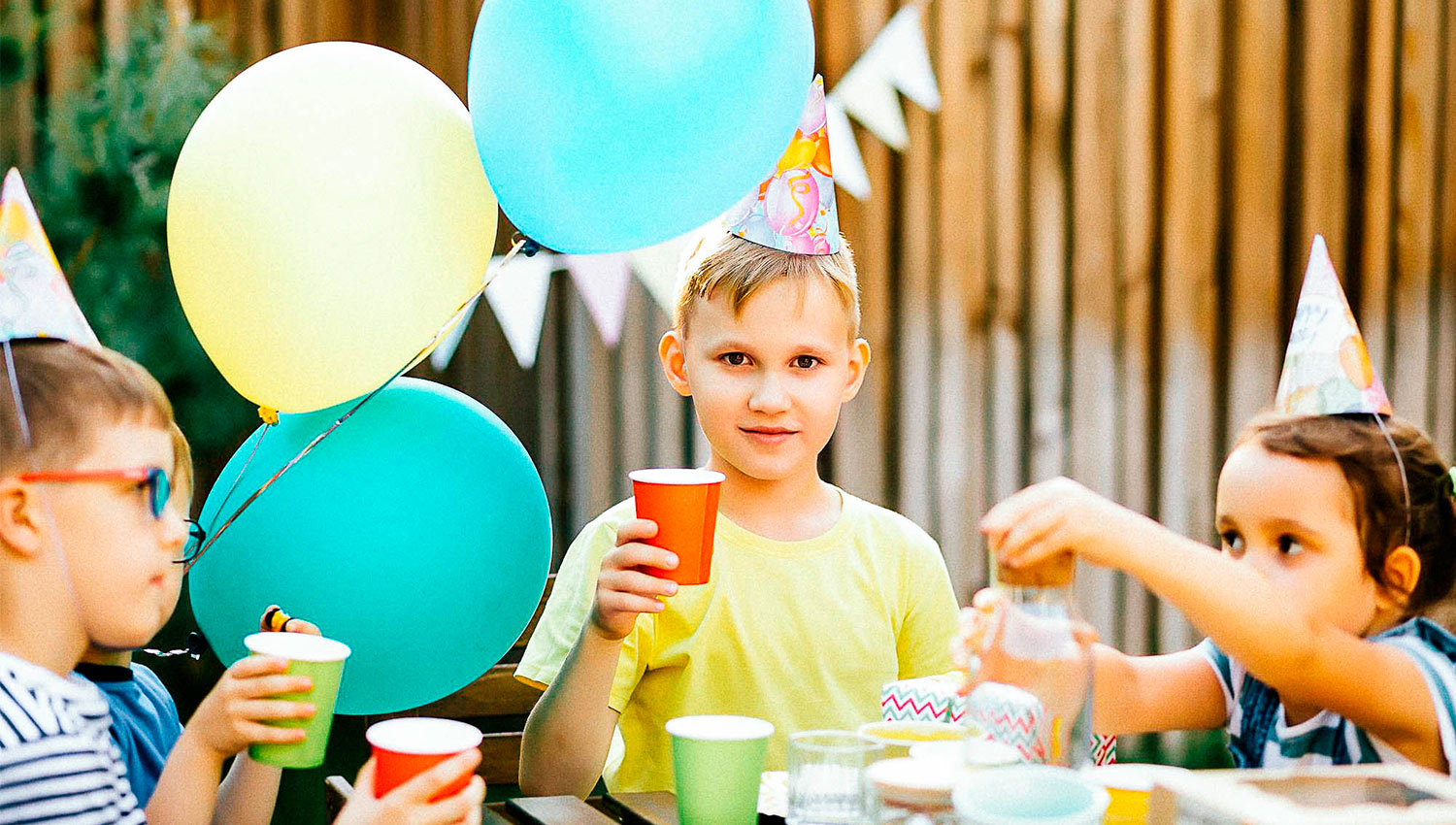 cute funny boy celebrating his birthday party with brothers and sisters