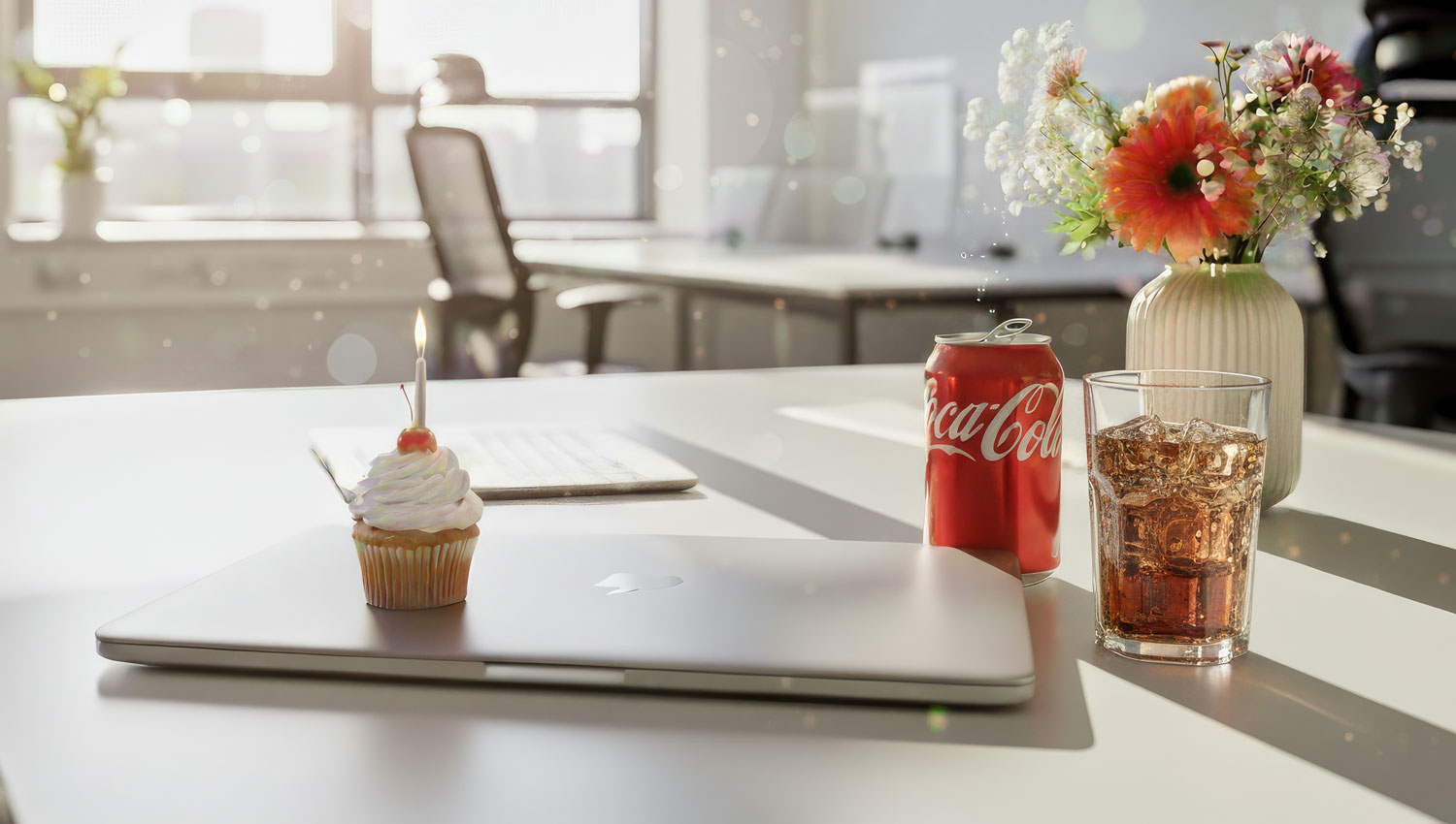 A single cupcake next to a laptop closed shut. Visual metaphor for work paused, life still worth celebrating.