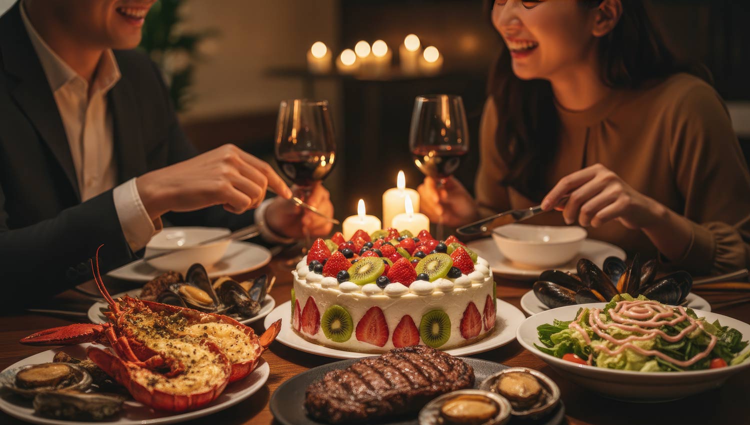 two people laughing at a birthday dinner, candlelight between them