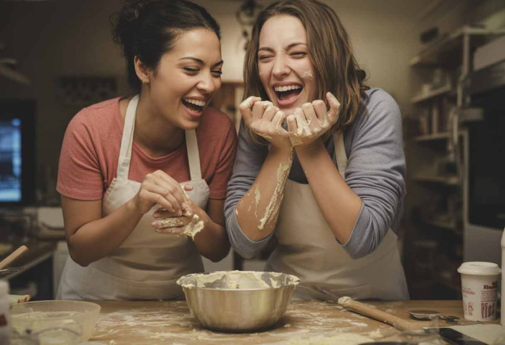 Friends laughing with frosting on their faces.