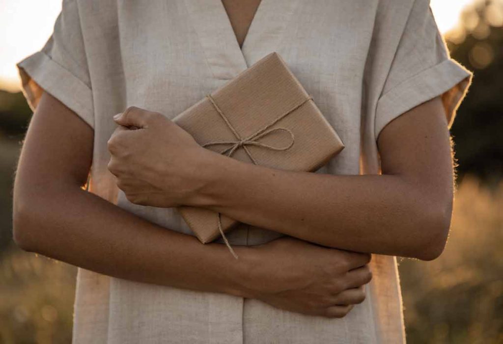 A person holding a small wrapped birthday gift